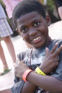 Little Boy crossing his arms with a peace sign